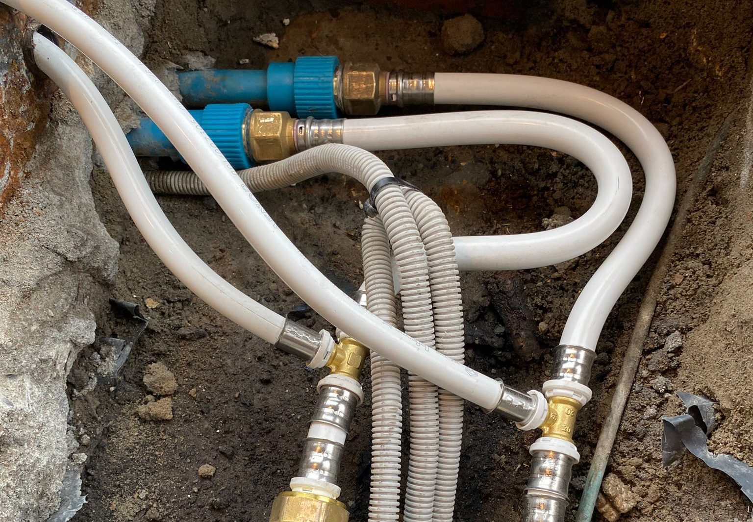Na het lek opsporen: nieuwe meerlaagse waterleidingen aangesloten op de oude leidingen onder de vloer