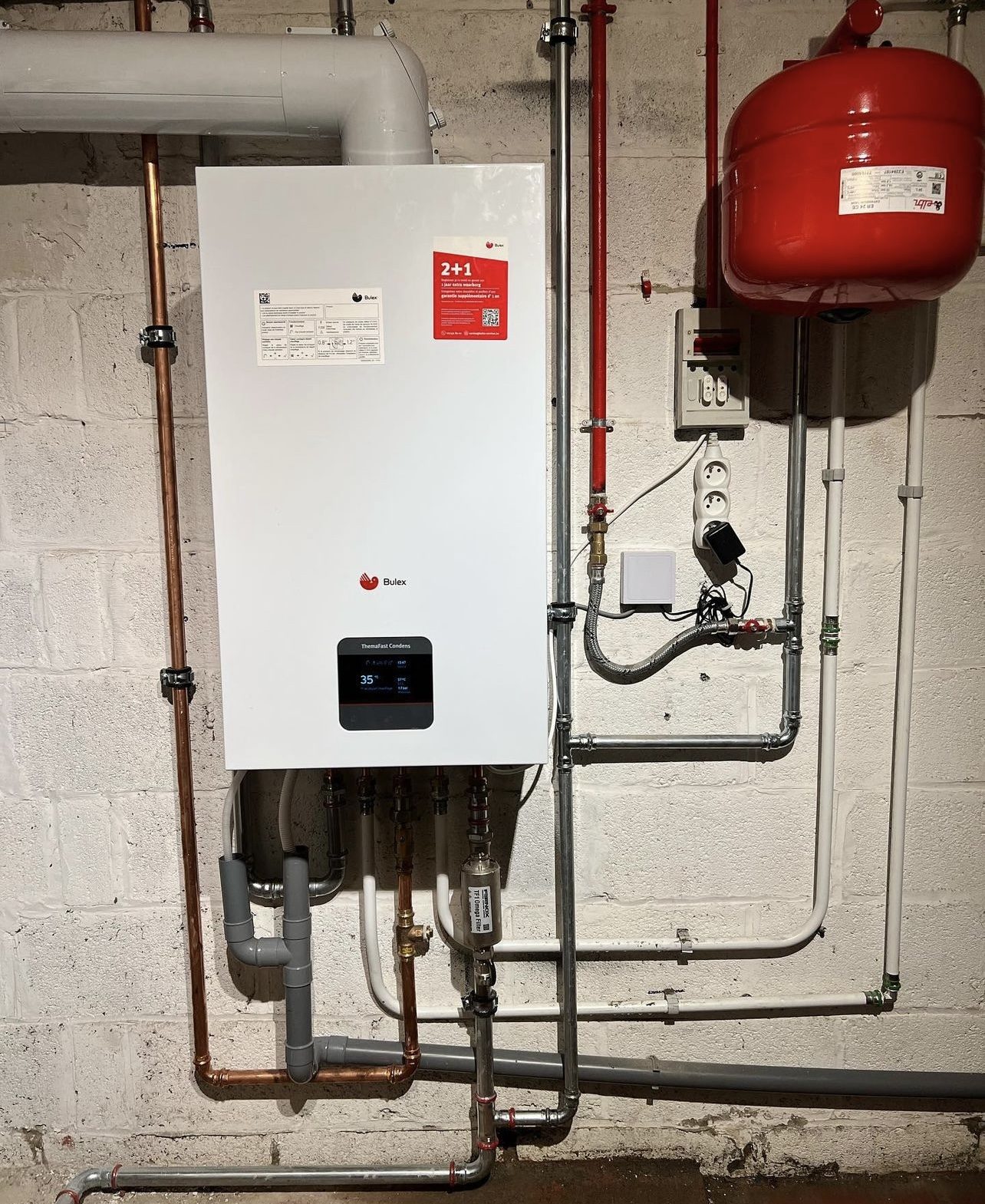 Nieuwe Bulex-ketel in een kelder, met een rood expansievat en nieuwe leidingen