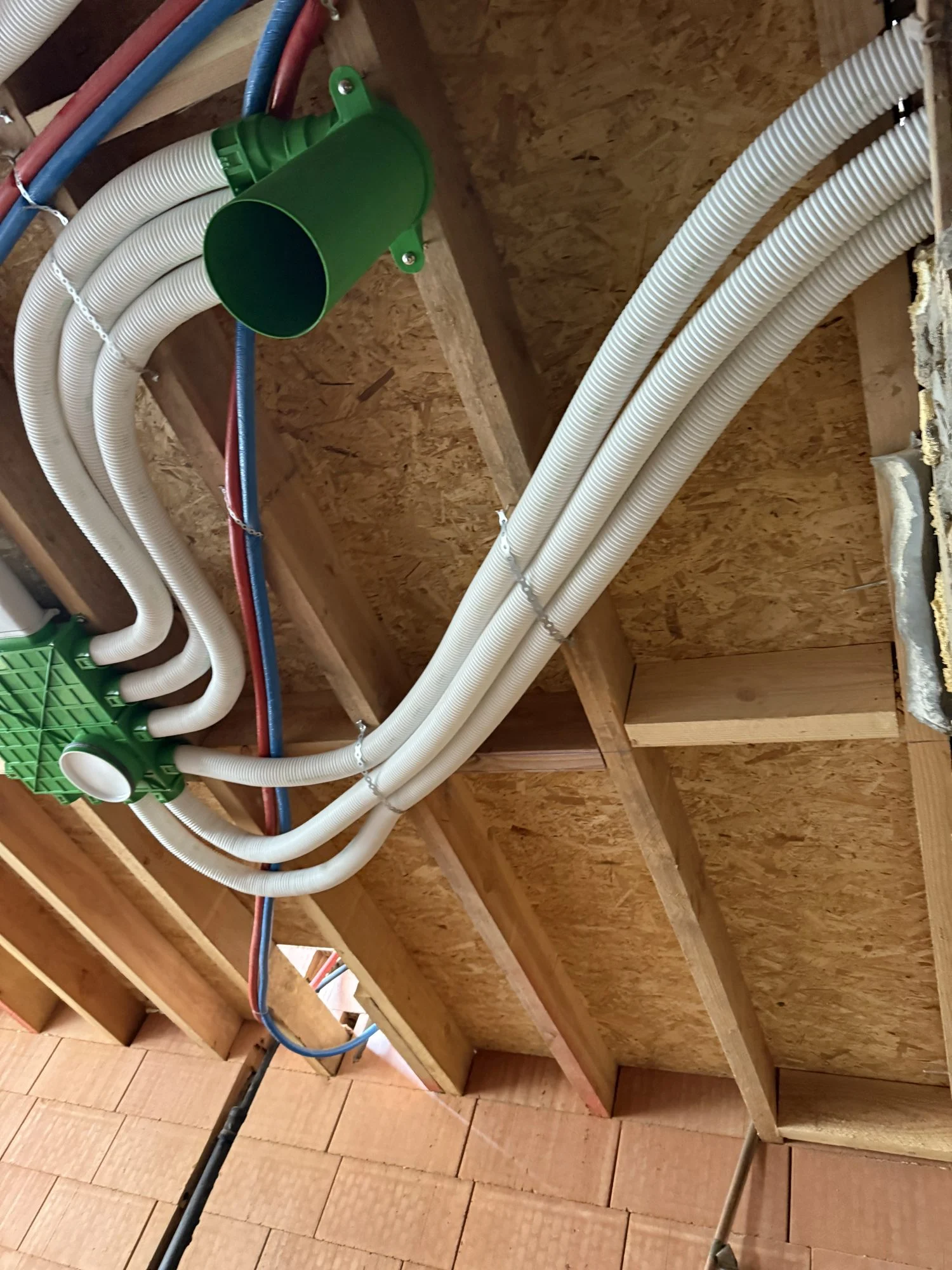 Ventilatiekanalen en waterleidingen in een houten plafond